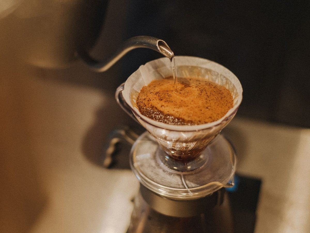 Barista preparing pour-over coffee at a café counter